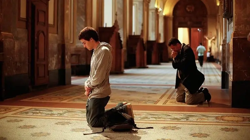 Two men kneeling in church