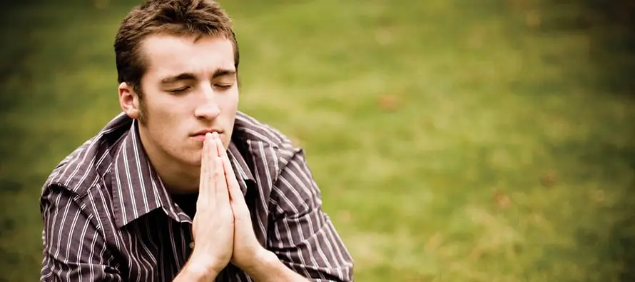 man praying with eyes closed