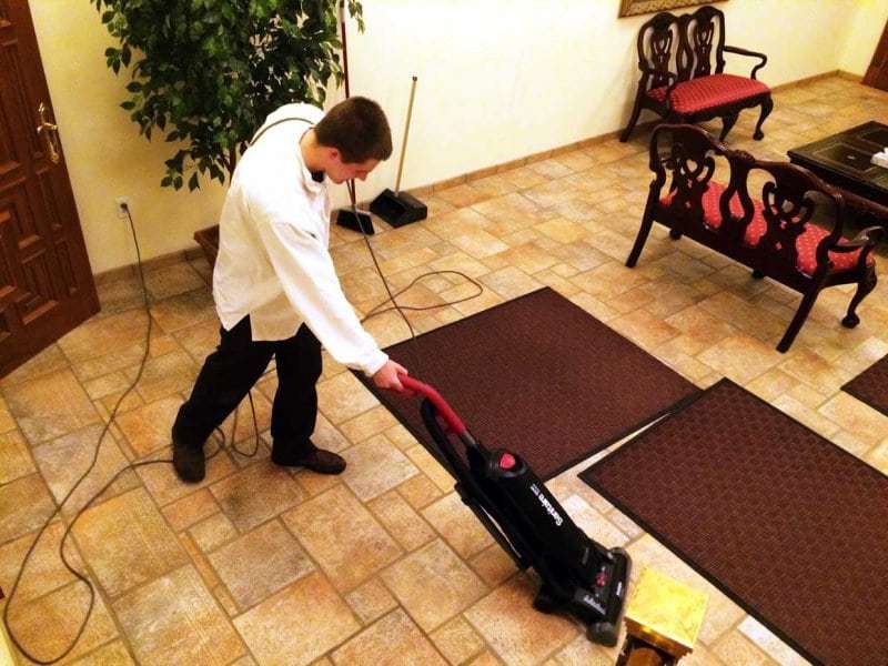 Knight of the Holy Eucharist vacuuming a carpet