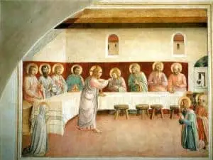 A Renaissance-style painting depicts Jesus and his disciples seated at a long table indoors, sharing a meal. Jesus stands at the center, offering bread, while two figures kneel in the foreground, and a woman prays at the table’s end.