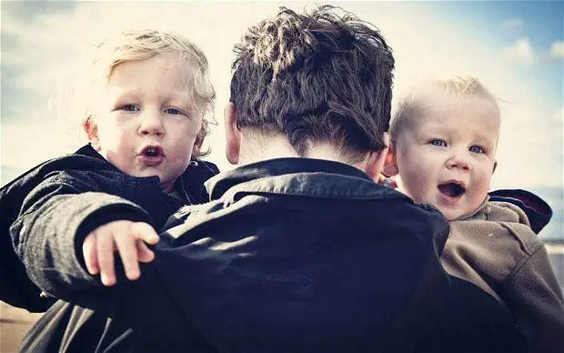 Father holding two cute little boys
