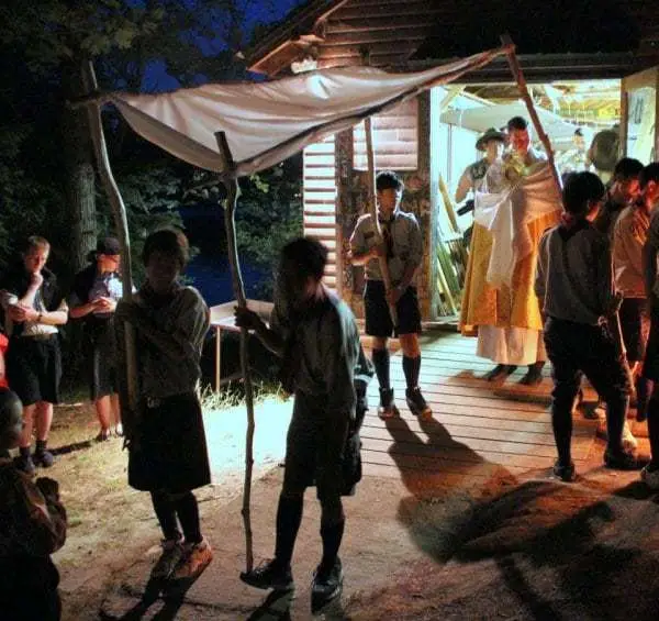 scouts with priest holding the Most Blessed Sacrament