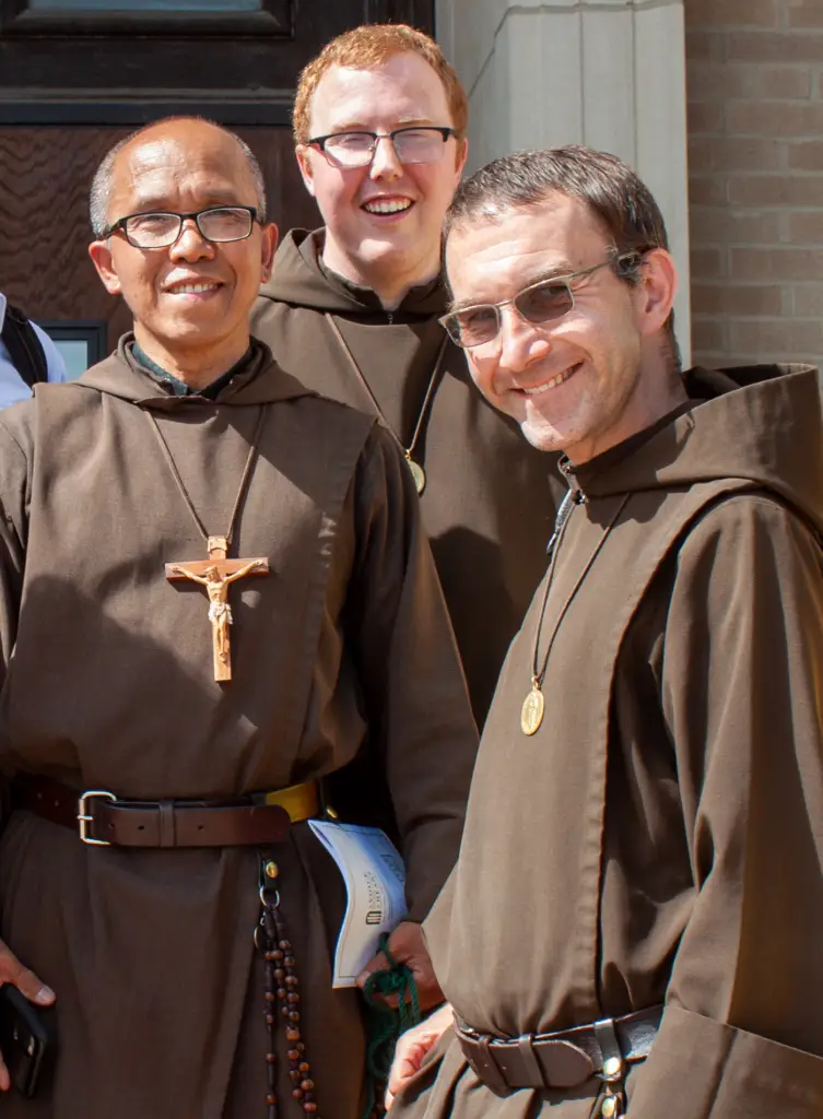 Br. Joseph, Br. Julian, and Br. Athanasius, Franciscan brothers of the Knights of the Holy Eucharist, smiling together in their brown habits