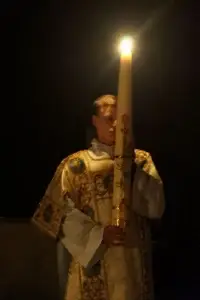 Paschal candle burning in a darkened church.